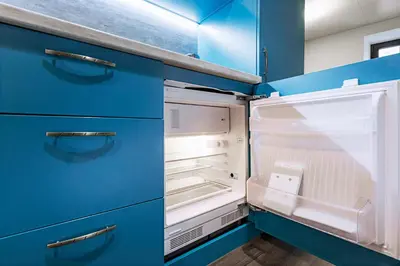 an empty blue kitchen with an open refrigerator at Charming Apartment in Historic Old Town in Prague
