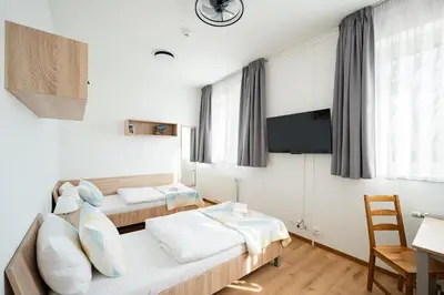 a small bedroom with a bed and a tv at University Hotel in Prague