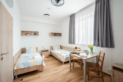 a bedroom with a bed and a table and a window at University Hotel in Prague