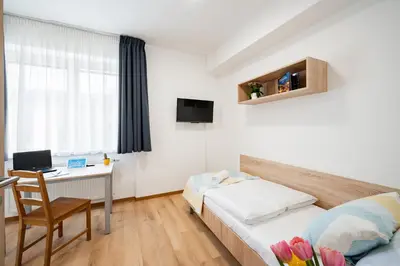 a bedroom with a bed with a colorful blanket at University Hotel in Prague