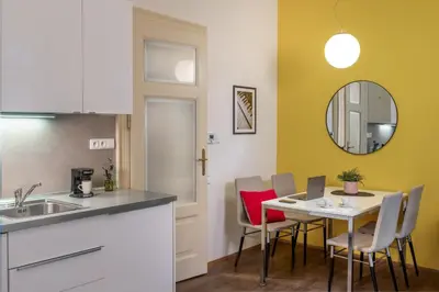 a kitchen and dining room with a table and chairs at 4 Arts Apartments by Adrez in Prague