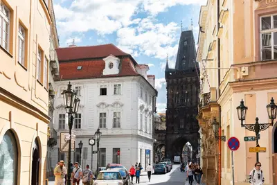 a group of people walking down a street with buildings at 4 Arts Apartments by Adrez in Prague
