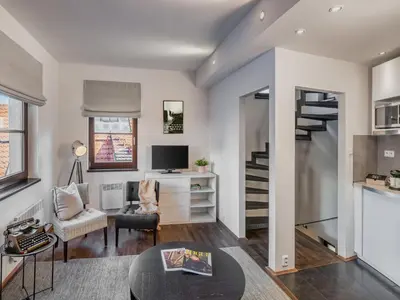 a living room with a staircase and a table and chair at 4 Arts Apartments by Adrez in Prague