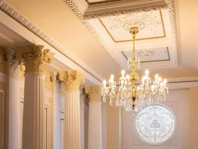 a chandelier hanging from a ceiling with columns at Beautiful apartment near Muzeum in Prague