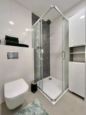 a white bathroom with a shower and a toilet at Beautiful apartment near Muzeum in Prague