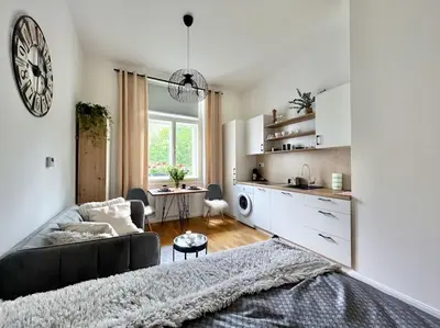 a living room with a black couch and a kitchen at Beautiful apartment near Muzeum in Prague