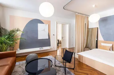 a bedroom with a bed and chairs and a couch at Unique stylish apartment - L3 in Prague