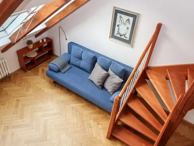 a blue couch in a living room next to a staircase at Apartment O21 by Interhome in Prague