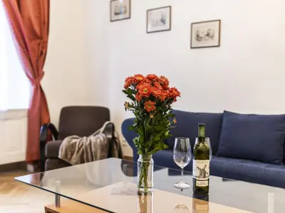 a table with a vase of flowers and two wine glasses at Apartment Manes Residence by Interhome in Prague