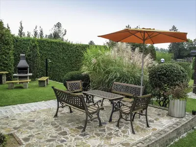 a table and chairs with an umbrella on a patio at Villa Petříkov by Interhome in Petříkov
