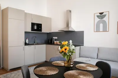 a kitchen and living room with a table with flowers on it at Apartment Dusni Superior in Prague