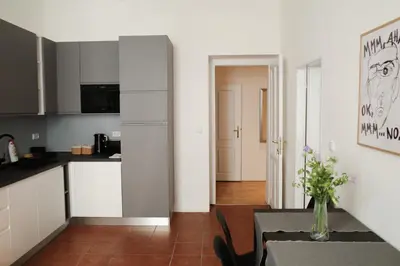 a kitchen with white cabinets and a table with a vase at Apartment Dusni Superior in Prague