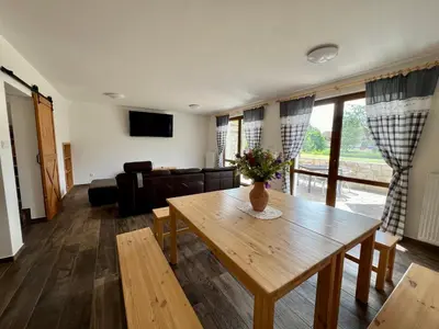 a living room with a table and a couch at Chalupa nad rybníkem in Straškov