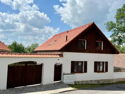 a house with a brown roof and a garage at Chalupa nad rybníkem in Straškov
