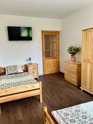a bedroom with two beds and a tv on the wall at Chalupa nad rybníkem in Straškov