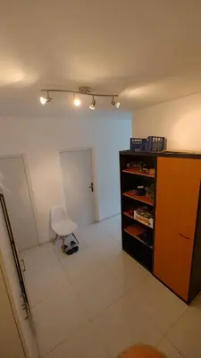 a room with a chair and a table and a shelf at Nomads room nearest forest Kamýk in Prague