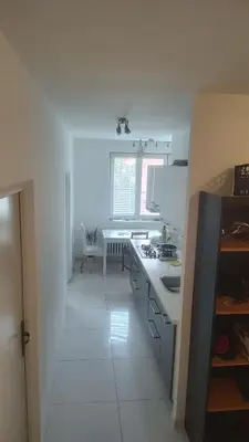 a kitchen with white cabinets and a white tile floor at Nomads room nearest forest Kamýk in Prague