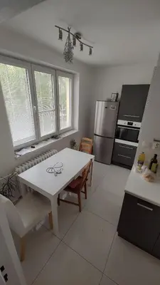 a kitchen with a white table and a white counter top at Nomads room nearest forest Kamýk in Prague