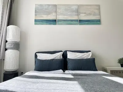 a bedroom with a bed with three paintings on the wall at JZP studio apartment in Prague