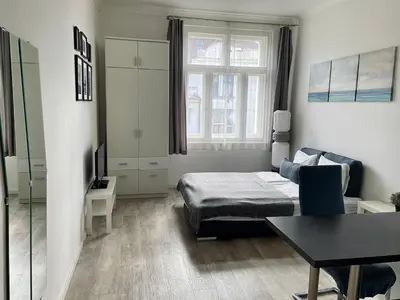 a small bedroom with a bed and a table at JZP studio apartment in Prague