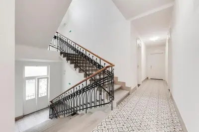 a white hallway with stairs in a house at JZP studio apartment in Prague
