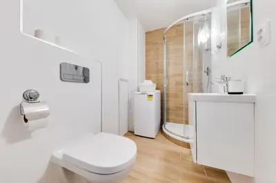 a white bathroom with a toilet and a sink at JZP studio apartment in Prague