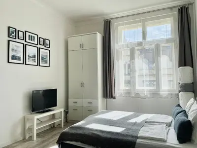 a bedroom with a bed and a tv and a window at JZP studio apartment in Prague