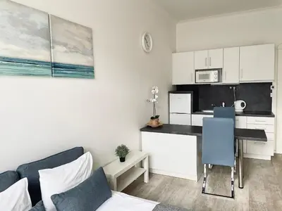 a living room with a table and a kitchen at JZP studio apartment in Prague