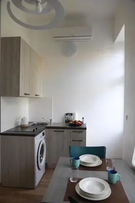 a kitchen with a table and a washing machine at Arbes 11 in Prague