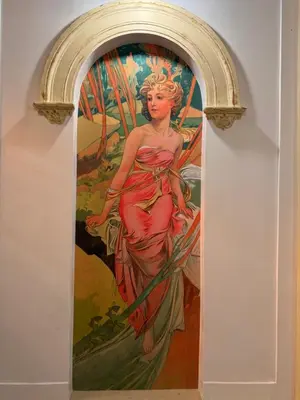 a painting of a woman in a red dress on a wall at Arbes 11 in Prague