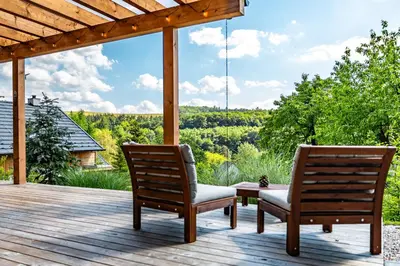 two chairs sitting on a deck with a view at Chata Kloučka Stříbrná Skalice in Stříbrná Skalice