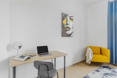 a desk with a laptop and a chair in a room at 3-bedroom apartment for family in Prague