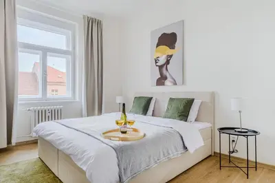 a bedroom with a bed with a table with wine glasses on it at 3-bedroom apartment for family in Prague