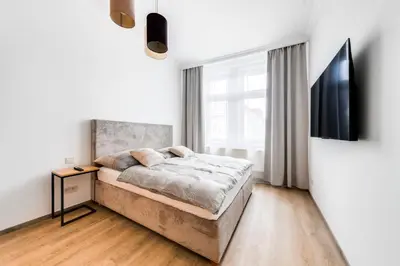 a white bedroom with a bed and a window at One bedroom Apartment at Sokolovska in Prague
