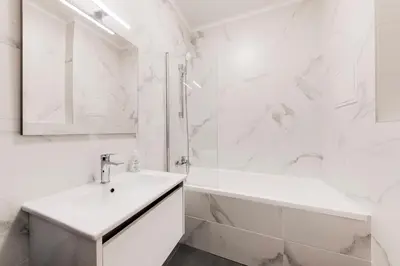 a white bathroom with a sink and a tub at One bedroom Apartment at Sokolovska in Prague