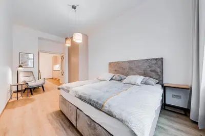 a bedroom with a large bed and a chair at One bedroom Apartment at Sokolovska in Prague