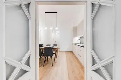 a kitchen and dining room with white walls and a table at One bedroom Apartment at Sokolovska in Prague