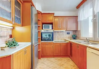 a kitchen with wooden cabinets and a stainless steel refrigerator at Apartment in center of Poděbrady in Nymburk
