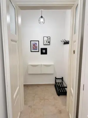 a hallway with a white wall with a light fixture at Viaduct View Apartment in Prague