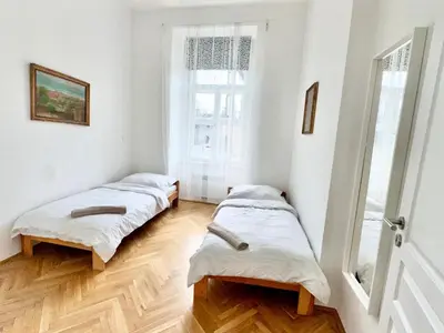 two beds in a room with a window at Viaduct View Apartment in Prague