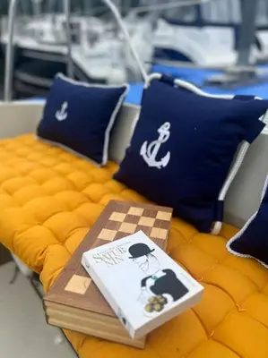 a bed with blue pillows and a book on it at Ubytování na plachetnici in Živohošť