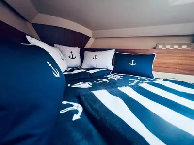 a bedroom with a bed with a blue and white comforter at Ubytování na plachetnici in Živohošť