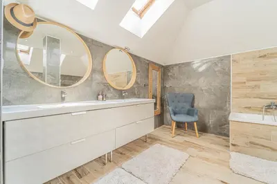 a bathroom with a sink and a mirror and a chair at Vila Sara s bazénem a infrasaunou na kraji Prahy in Zbuzany