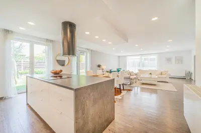 a kitchen and living room with a counter and a table at Vila Sara s bazénem a infrasaunou na kraji Prahy in Zbuzany