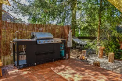 a barbecue grill in a backyard with a fence at Tiché místo Glamping in Slapy