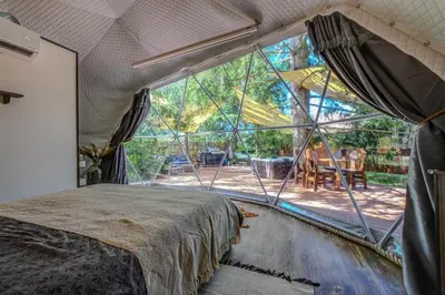 a bedroom with a bed and a large window at Tiché místo Glamping in Slapy
