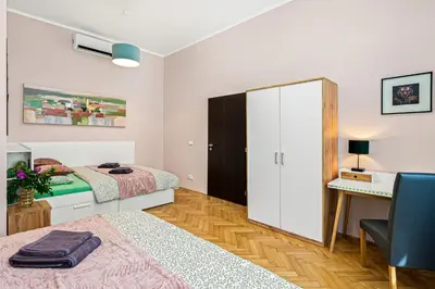 a bedroom with two beds and a desk and a cabinet at Oasis Apartments at Charles Square in Prague