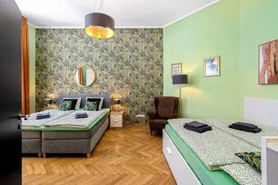 a room with two beds and a chair in it at Oasis Apartments at Charles Square in Prague