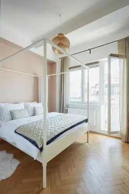 a bedroom with a white bed with a metal canopy at Luxury riverside apartment in Prague