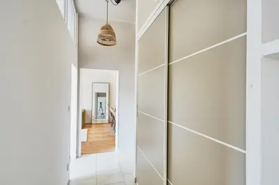 a hallway with white walls and a glass door at Luxury riverside apartment in Prague